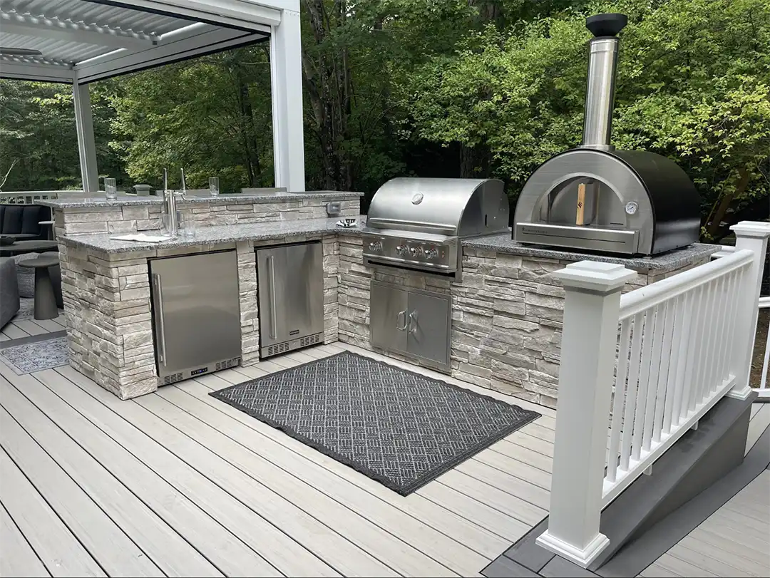 hoto of an L-Shaped outdoor kitchen featuring a kegerator and an outdoor pizza oven with a gas disconnect.